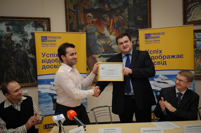 Dmitry Musiyenko, Piraeus Bank in Ukraine memeber of management board (right) gives check for the charity event 